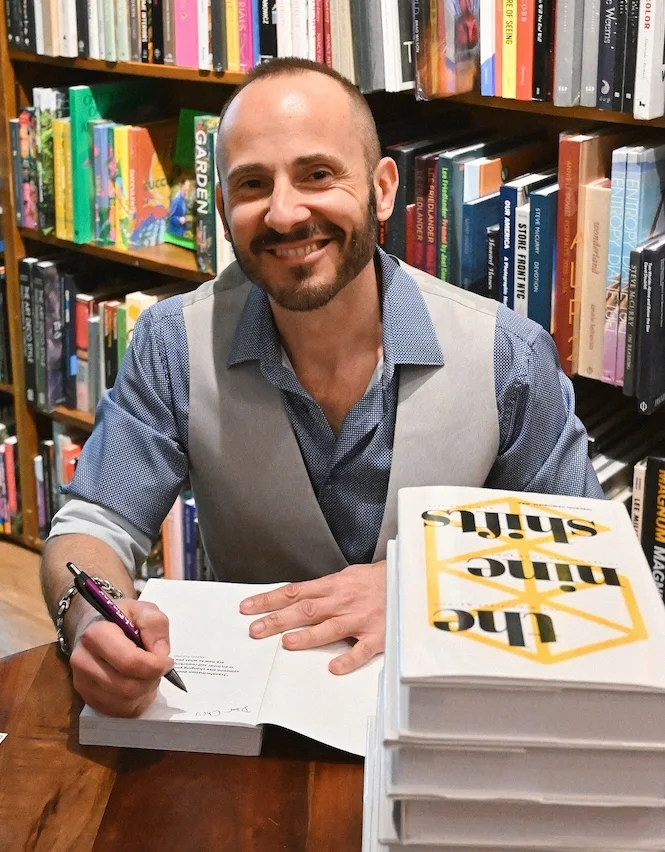 Deekron signing a stack of The Nine Shifts at Books & Books